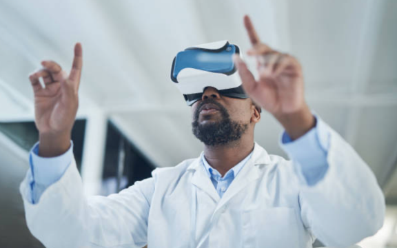 Ein Wissenschaftler nutzt eine Virutal-Reality-Brille und zeigt mit seinen beiden Händen auf